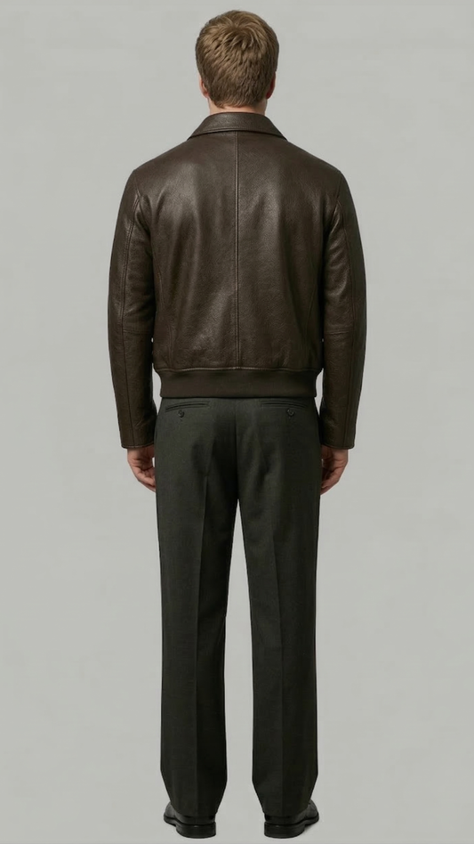 Man wearing a brown leather jacket and dark pants on a gray background