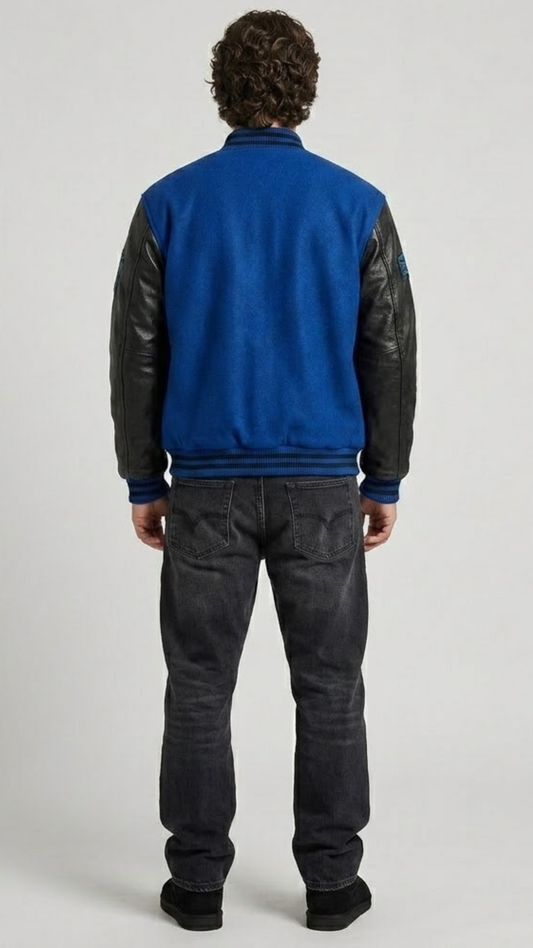 Detailed view of the athletic striped rib-knit collar, cuffs, and waistband on a premium blue suede varsity jacket.