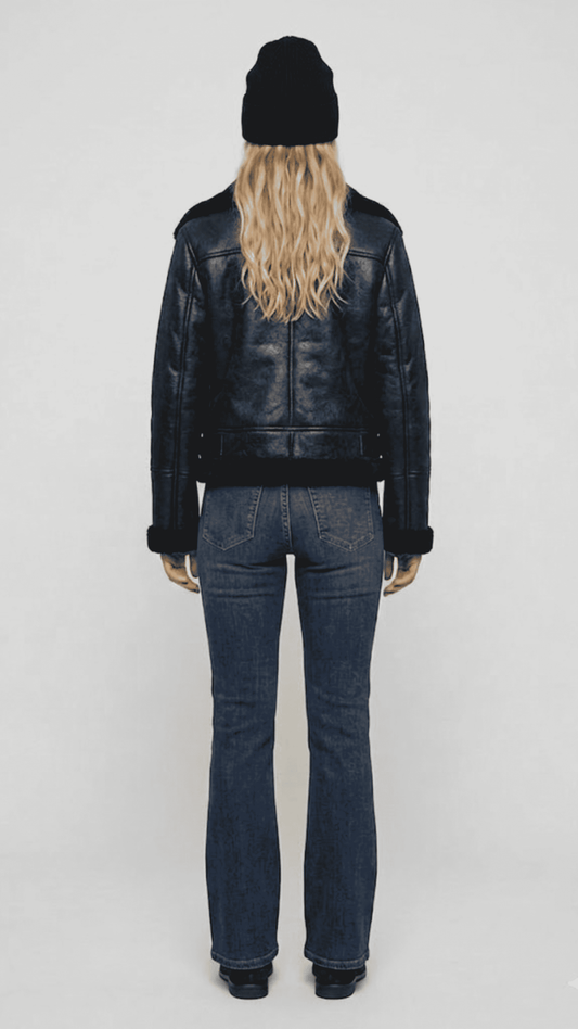 Rear view of the black leather shearling jacket showing the seamless stitching and comfortable heavy winter fit.