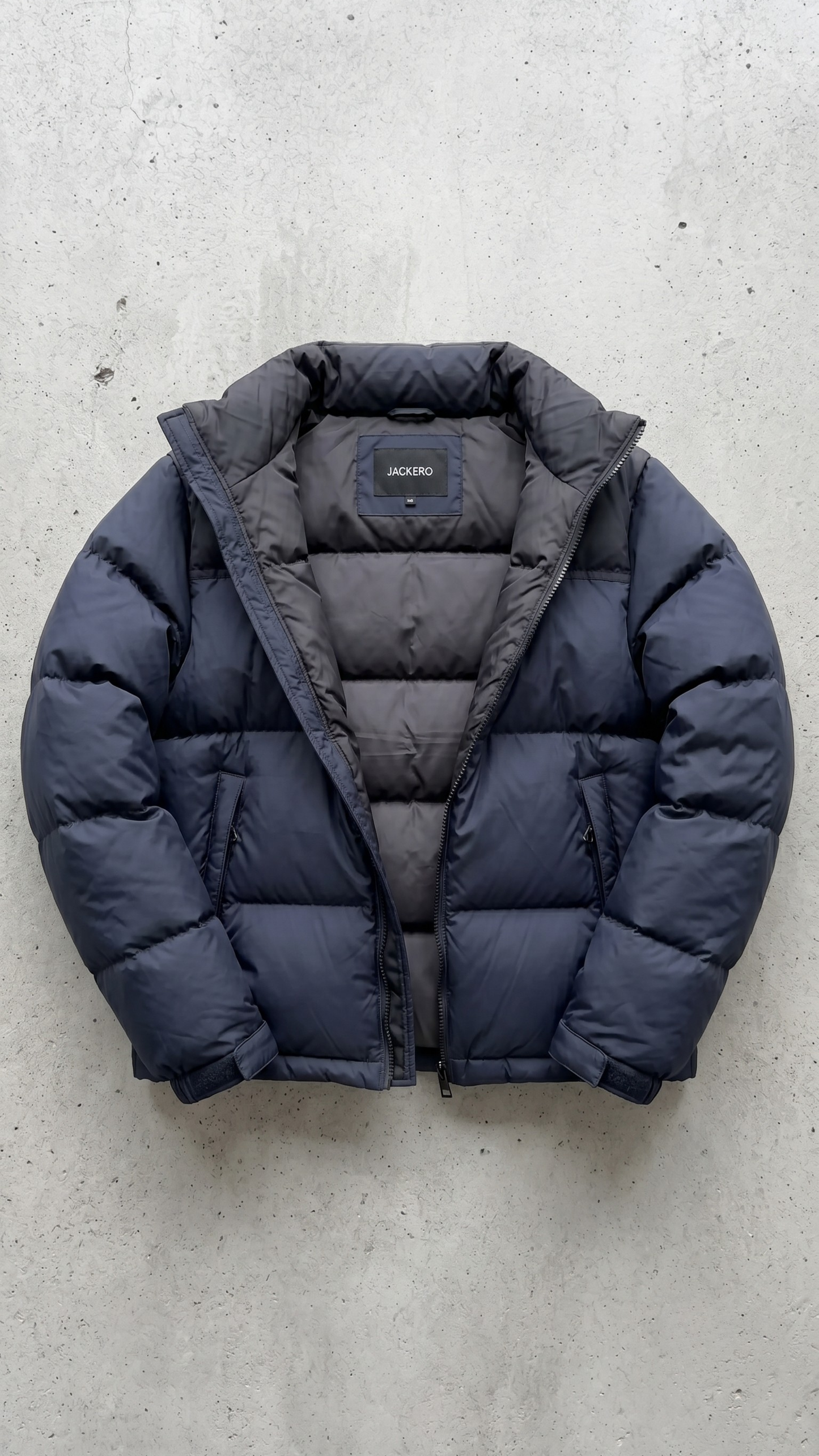 Detailed look at the protective high collar and cuffs of a navy blue quilted puffer jacket.