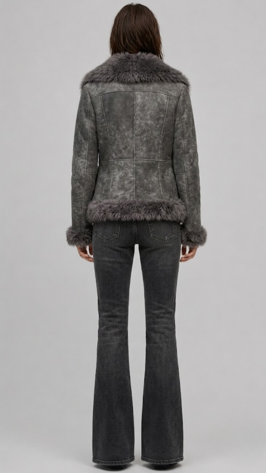 Model wearing a JACKERO fitted grey fur-trimmed shearling coat paired with a white crop top and high-waisted black flare jeans.