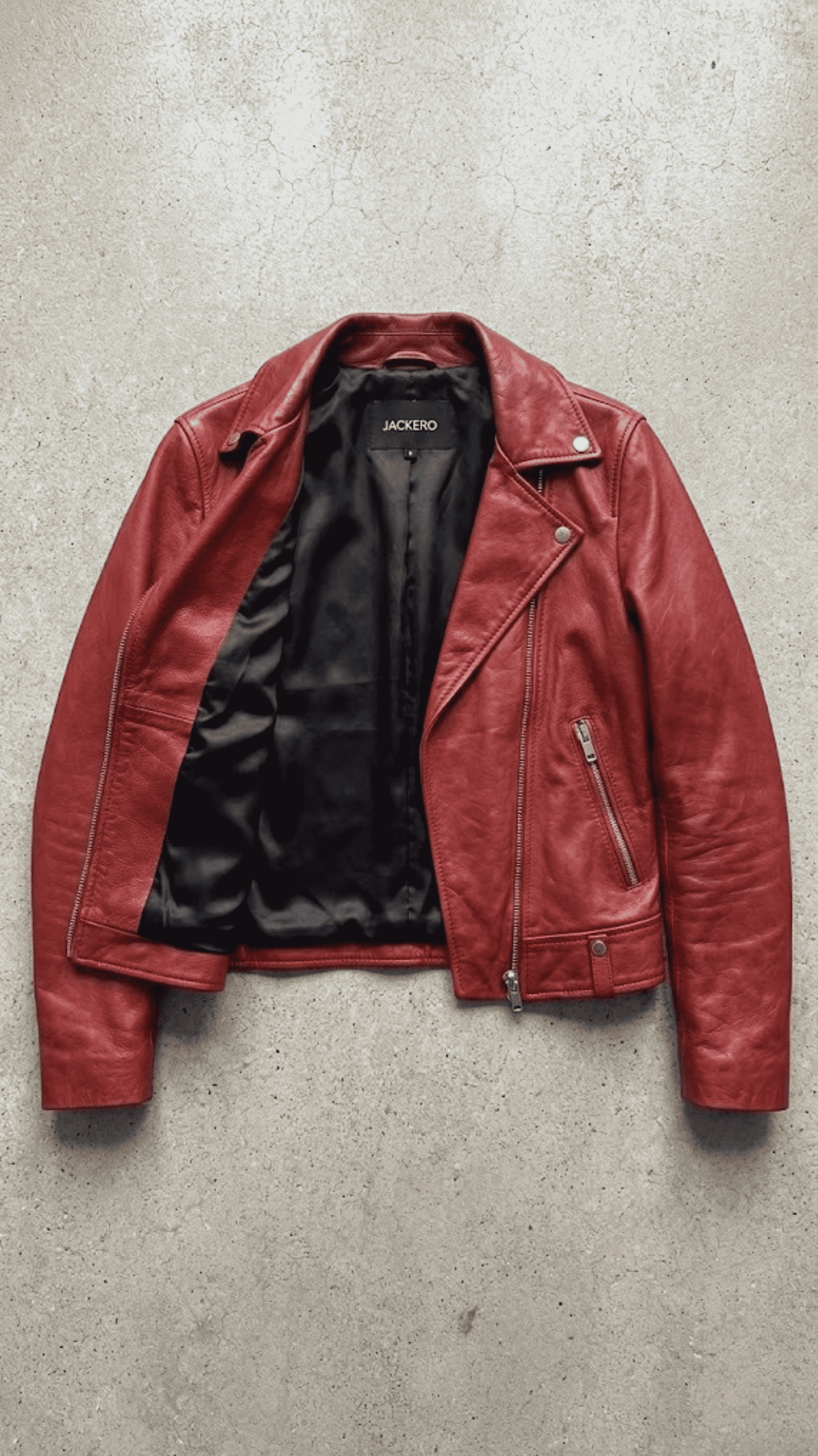 Jackero jacket flat lay photography of a high-end scarlet red leather motorcycle coat displayed on a solid grey backdrop.