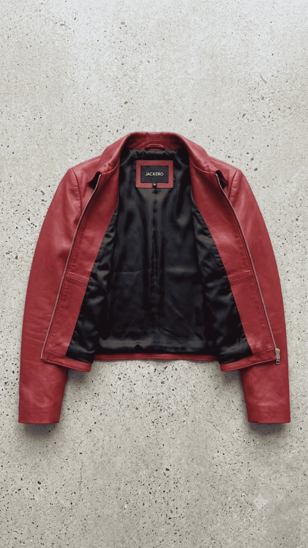 Jackero jacket flat lay photography of a high-end crimson red leather café racer coat displayed on a solid grey backdrop.