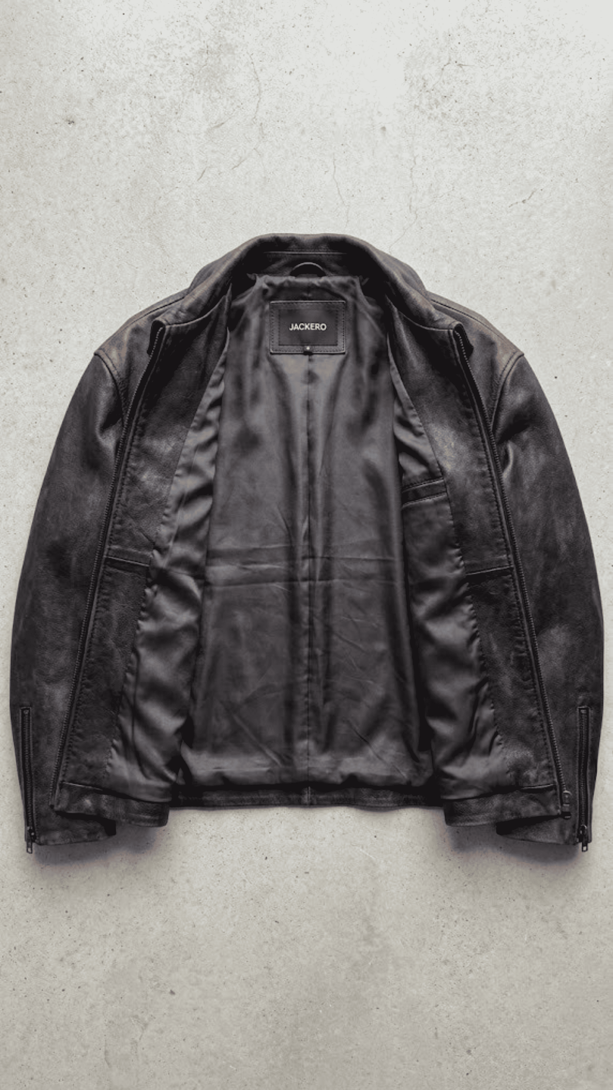 Clean jackero jacket catalog flat lay of a premium black leather button-down trucker outerwear on a solid grey backdrop.