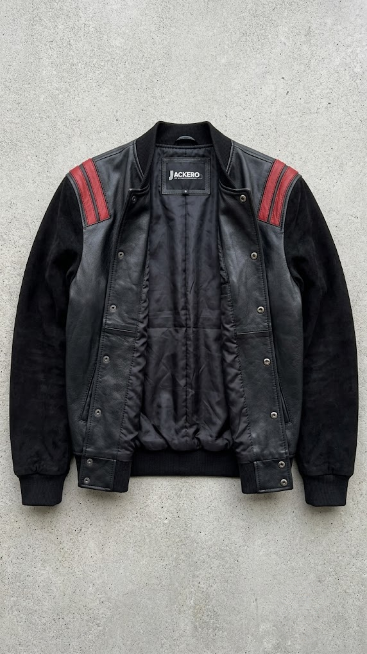 Jackero black and red leather bomber outerwear beautifully presented against a clean, minimalist studio backdrop.