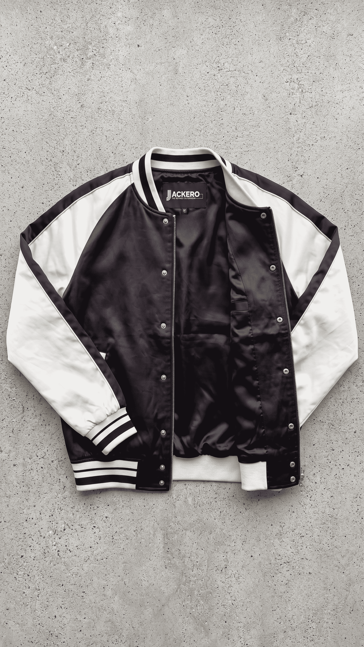 Jackero black and white tricolor varsity jacket beautifully showcased against a clean, minimalist studio backdrop.