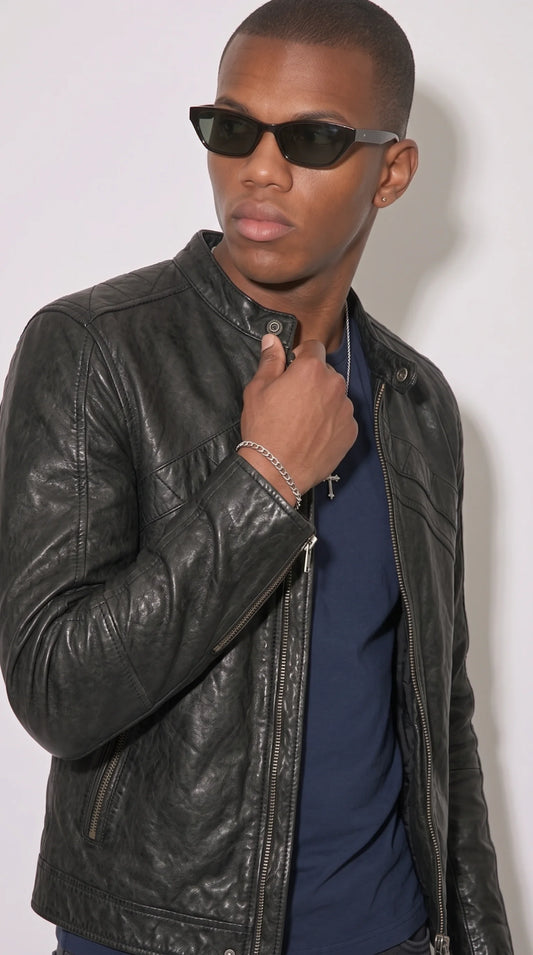 A jet-black leather trucker jacket styled for modern urban streetwear, with a clean structured shape and utility-inspired chest pockets that pair naturally with denim, plain T-shirts and casual boots for a confident city-ready outfit.