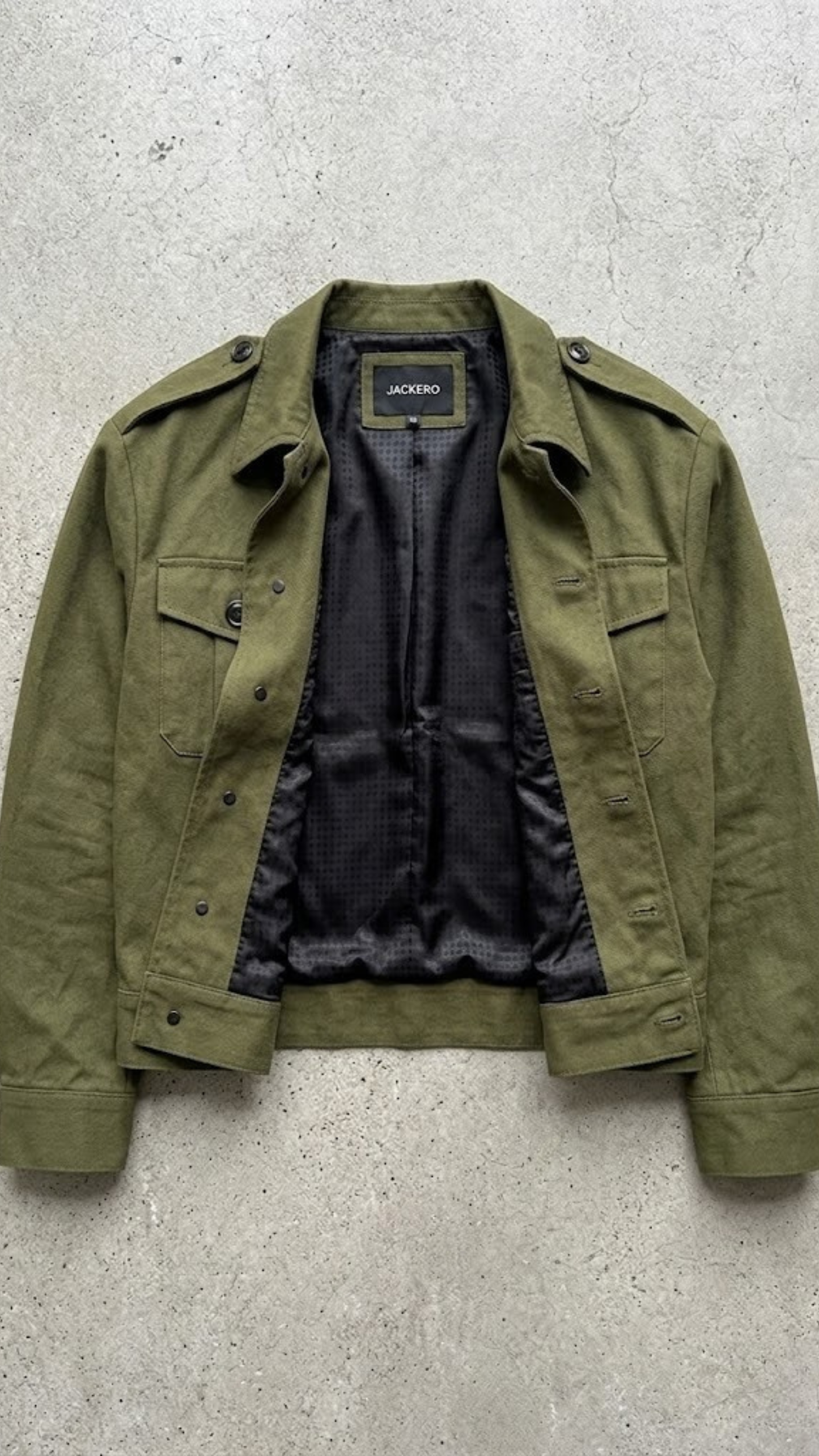 Flat lay view of Jackero premium olive green cotton jacket on a clean studio background
