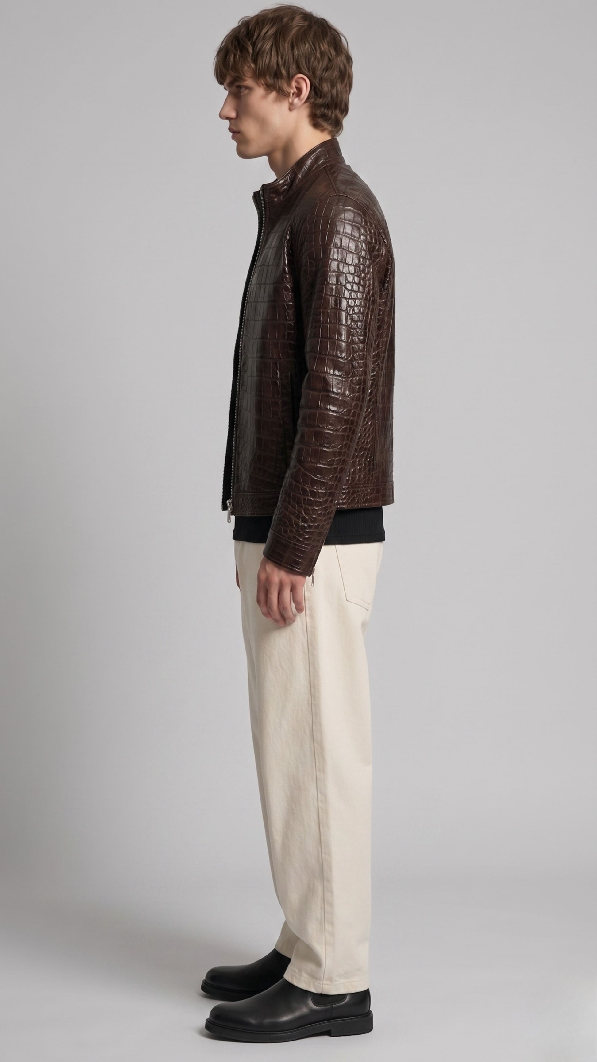 Man wearing a brown textured jacket and beige pants on a gray background