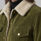 Close-up of a person wearing a green jacket with a beige sherpa lining on a neutral background