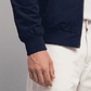 Close-up view of side welt hand pockets and smooth metal zipper slide on dark navy cotton outerwear