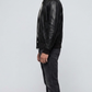 Side angle profile view highlighting the classic tailored collar line and polished silver-tone hardware zipper of the minimalist black outerwear.