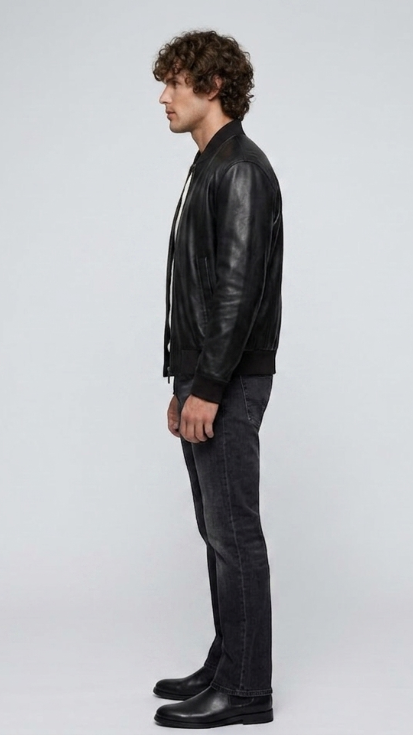 Side angle profile view highlighting the classic tailored collar line and polished silver-tone hardware zipper of the minimalist black outerwear.
