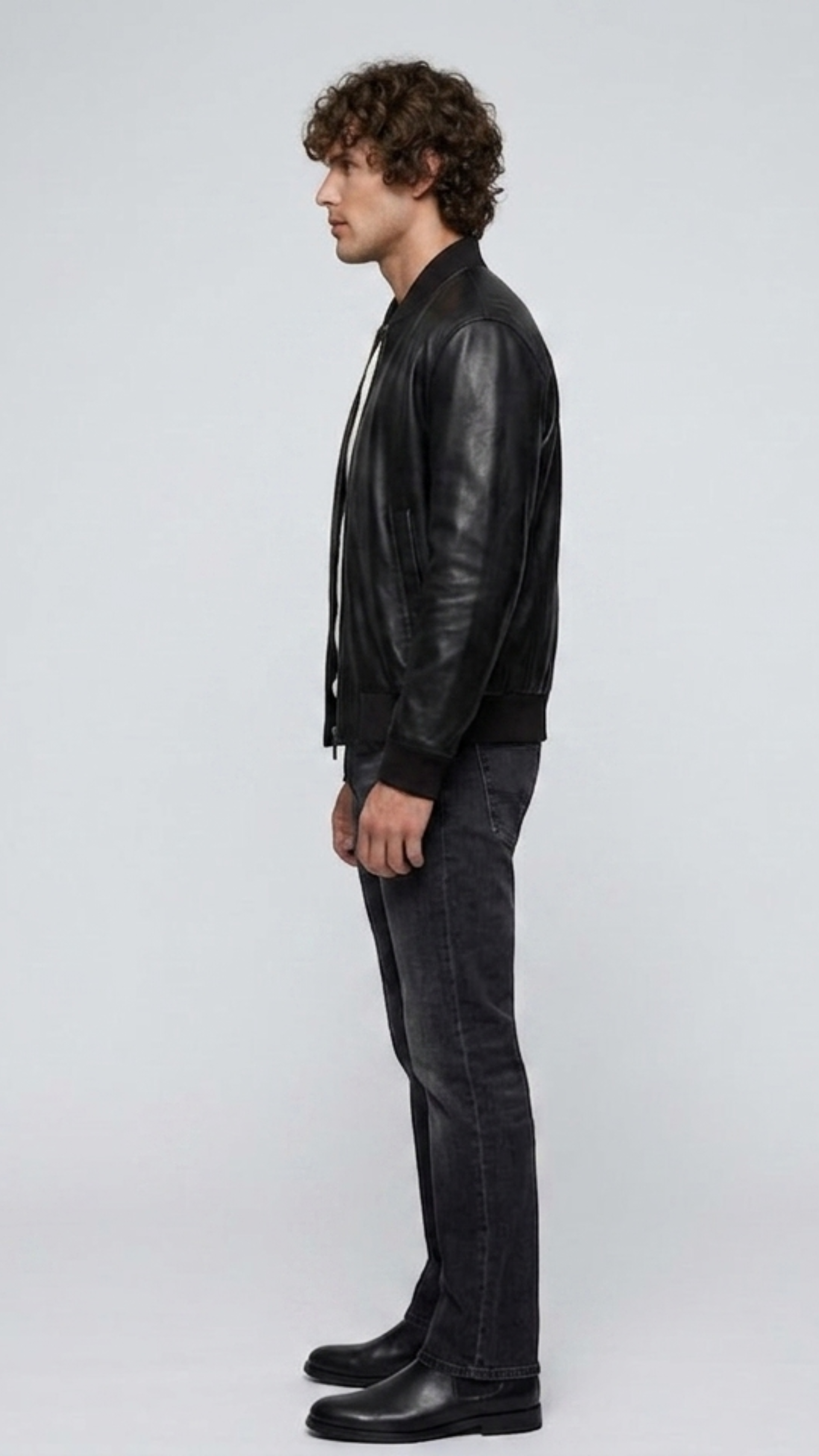 Side angle profile view highlighting the classic tailored collar line and polished silver-tone hardware zipper of the minimalist black outerwear.