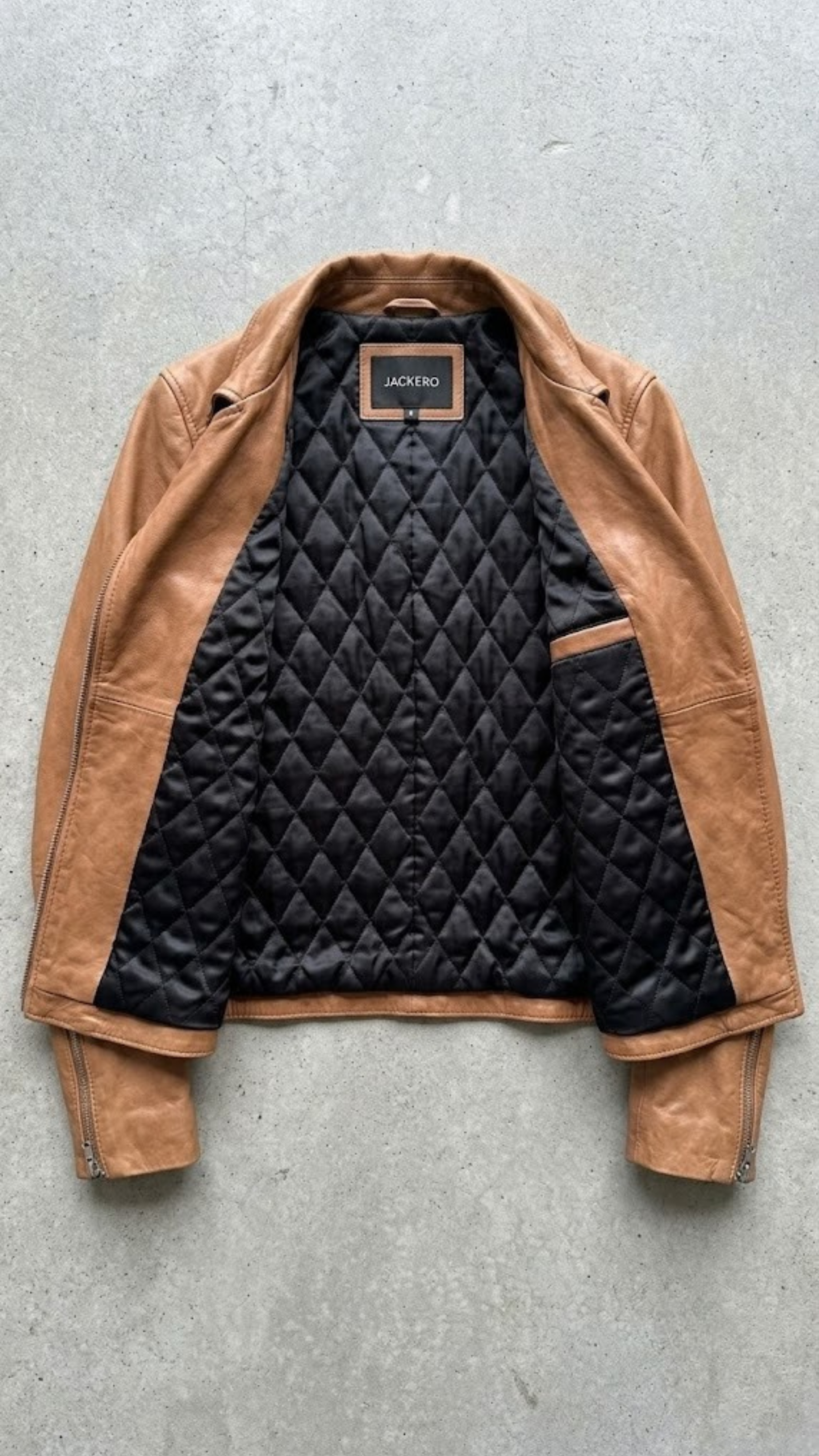 Jackero jacket flat lay presentation featuring the contemporary camel brown leather rider jacket neatly displayed on a neutral background.