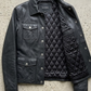 Jacker jacket flat lay presentation featuring the contemporary matte black leather shirt-collar jacket neatly displayed on a studio backdrop.