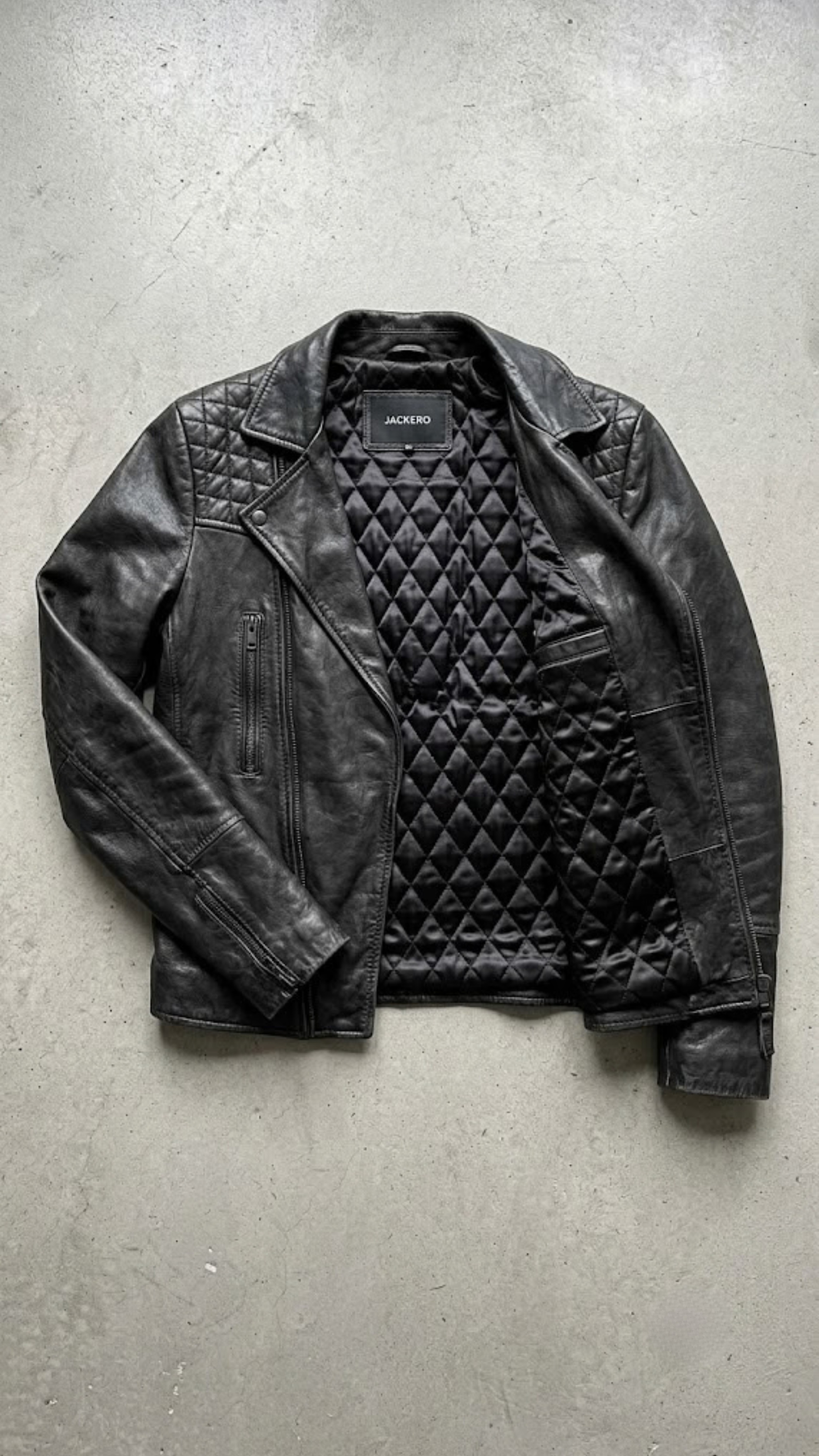 black motorcycle jacket perfectly displayed on a high-contrast background.
