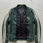 Green leather jacket with white stripes on sleeves on a gray concrete surface