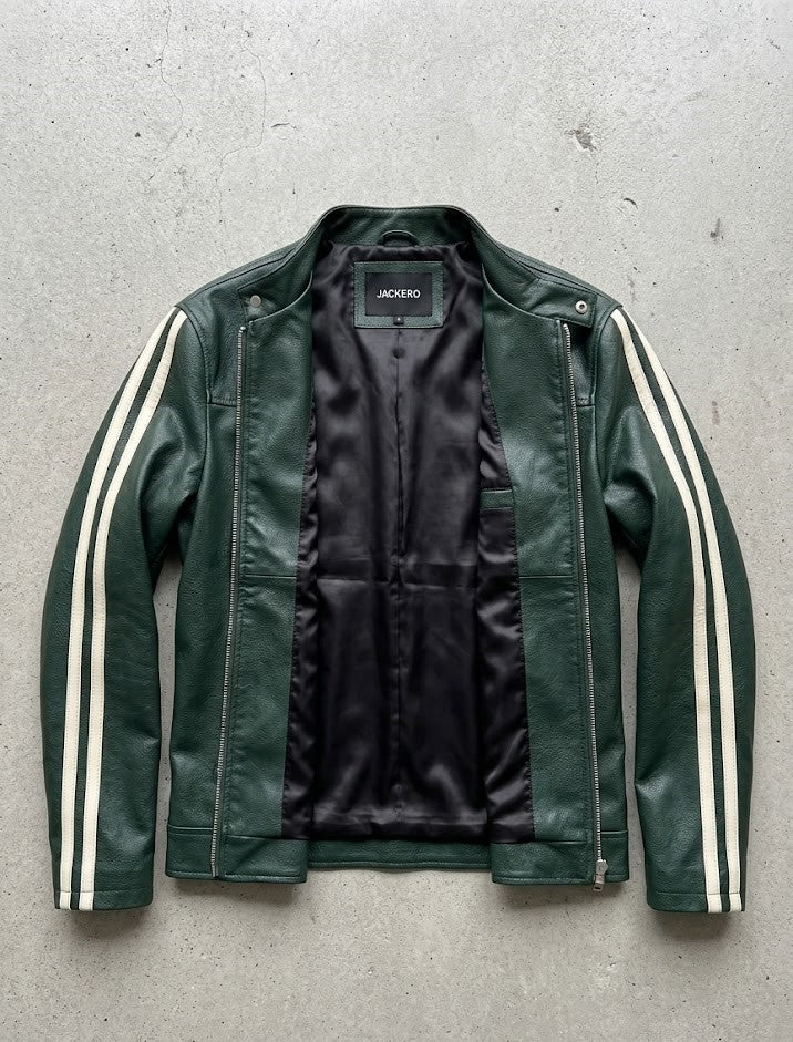 Green leather jacket with white stripes on sleeves on a gray concrete surface