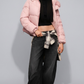 Front view of a model wearing a cozy baby pink puffer jacket with a plush pink fur hood, posed against a solid grey studio background.