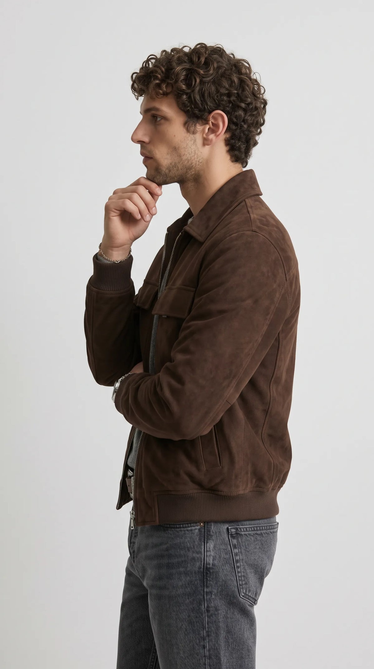 Dark chocolate-brown suede outerwear designed with broad dropped shoulders, a slouchy oversized fit, a structured point collar and a full-length zip closure. The relaxed shape gives the jacket a contemporary baggy aesthetic, while the rich brown suede surface brings a premium texture to casual layering, loose-fit trousers and modern street-inspired outfits.
