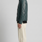Side angle profile view highlighting the heavy-duty tailored zipper elements and contrasting stitch lines of the deep teal leather outerwear.