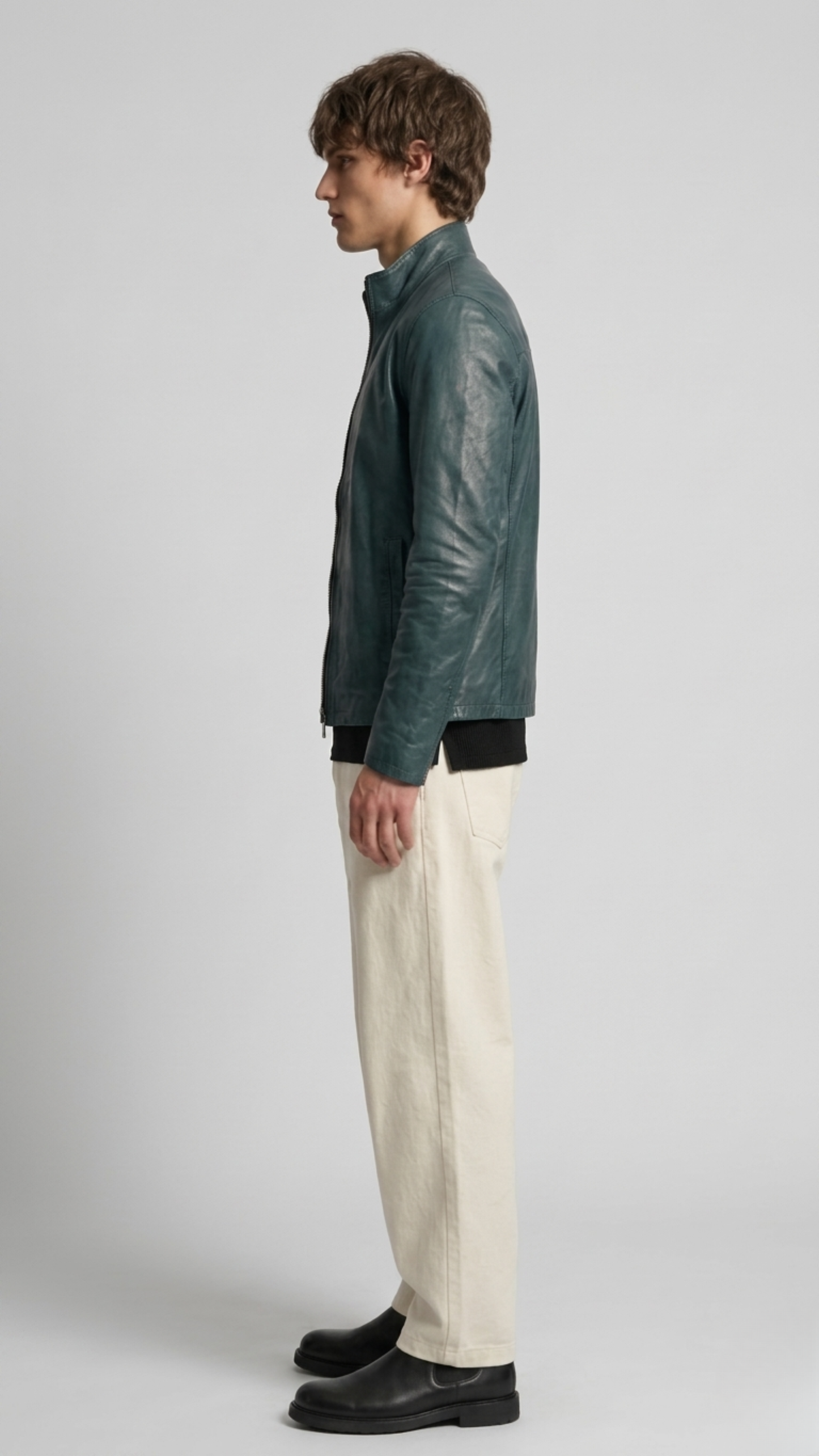 Side angle profile view highlighting the heavy-duty tailored zipper elements and contrasting stitch lines of the deep teal leather outerwear.