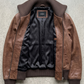 flat lay presentation featuring the luxury dark walnut brown leather bomber jacket arranged neatly on a crisp layout.