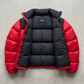 Professional product flat lay presentation displaying the premium red and black two-tone insulated puffer coat perfectly balanced on a grey studio background.