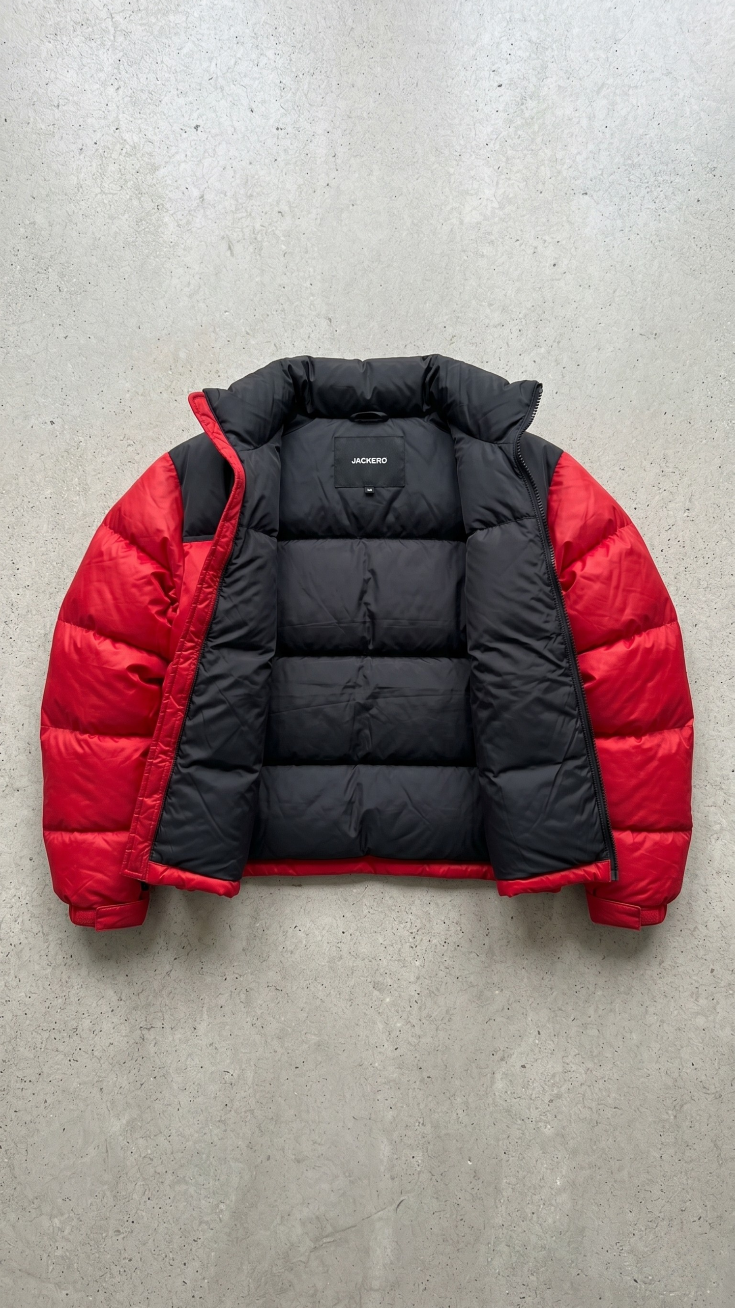 Professional product flat lay presentation displaying the premium red and black two-tone insulated puffer coat perfectly balanced on a grey studio background.