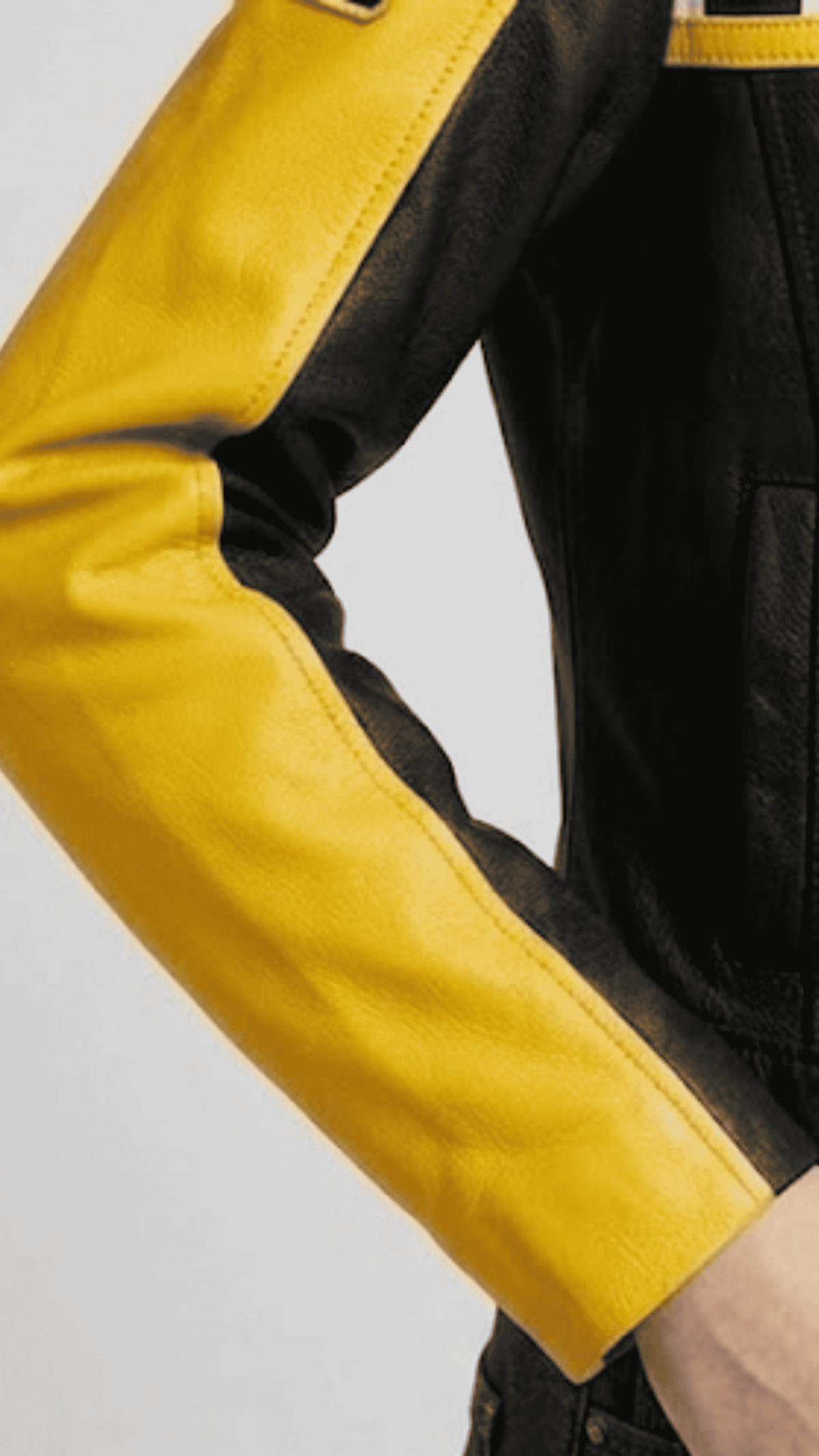 Close-up shot of the high-contrast yellow leather stripes and premium heavy-duty zippers on a black biker jacket.
