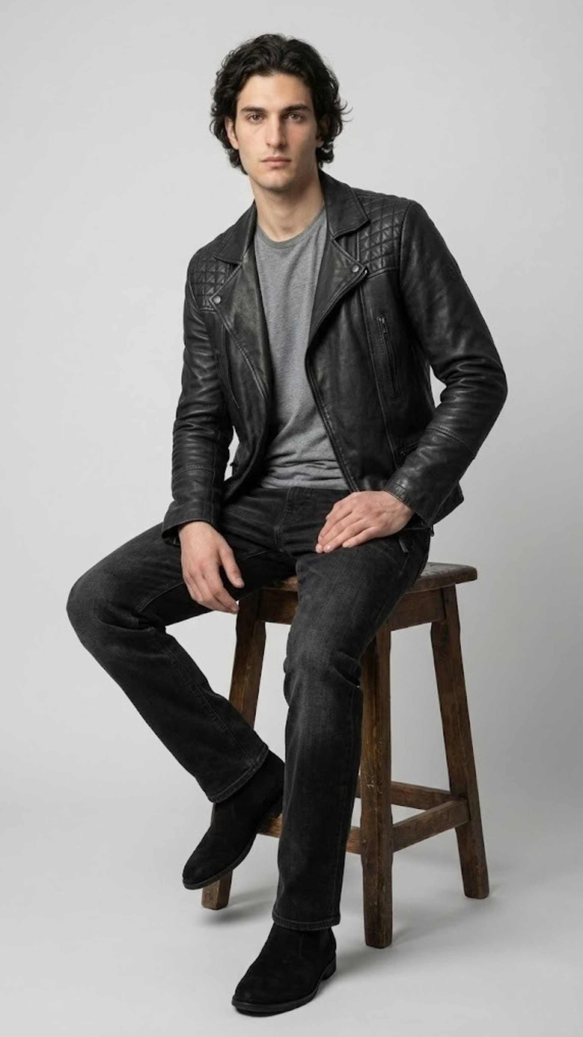 Premium men's style lookbook editorial showcasing a sharp monochromatic street outfit centered around a luxury stealth black rider coat.