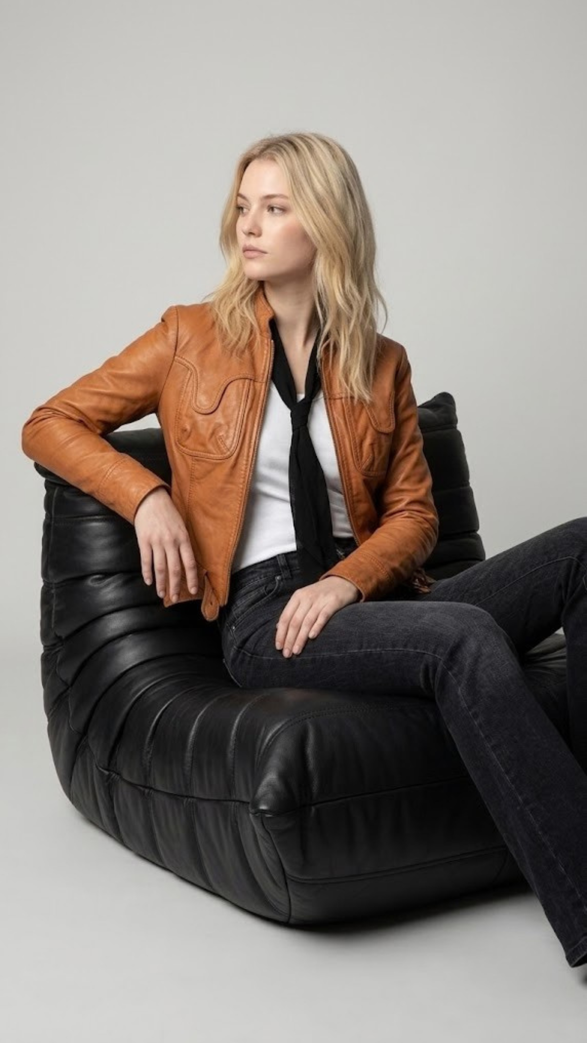 Premium women's style lookbook editorial showcasing a layered smart casual wardrobe aesthetic anchored by a luxury light brown leather motorcycle coat.