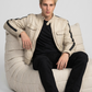 Premium men's fashion lookbook editorial showcasing a sophisticated neutral outfit centered around a luxury off-white leather rider coat.