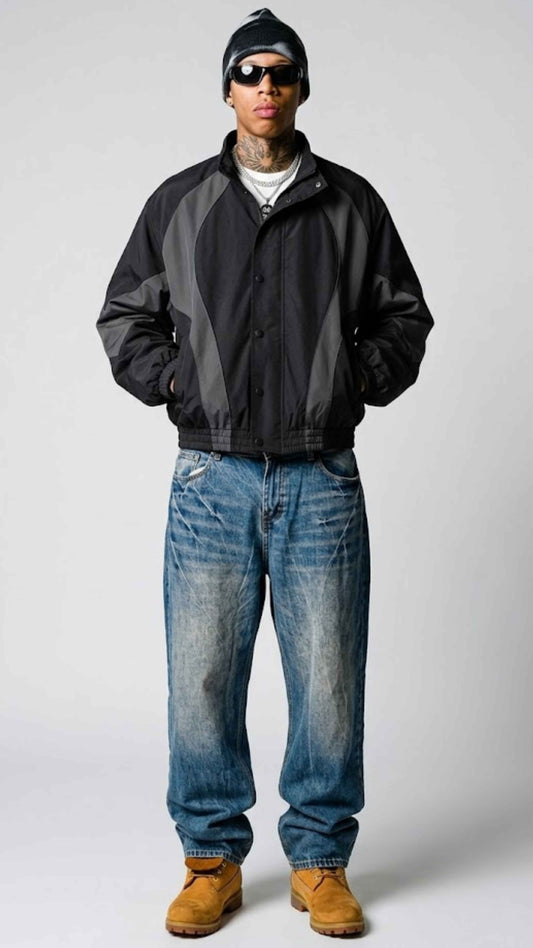 Front view of model wearing an oversized Y2K black and dark grey nylon jacket with full zip front and stand collar