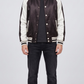 Front full view of premium black and white varsity jacket displaying the striking contrast between the dark body and crisp white sleeves.