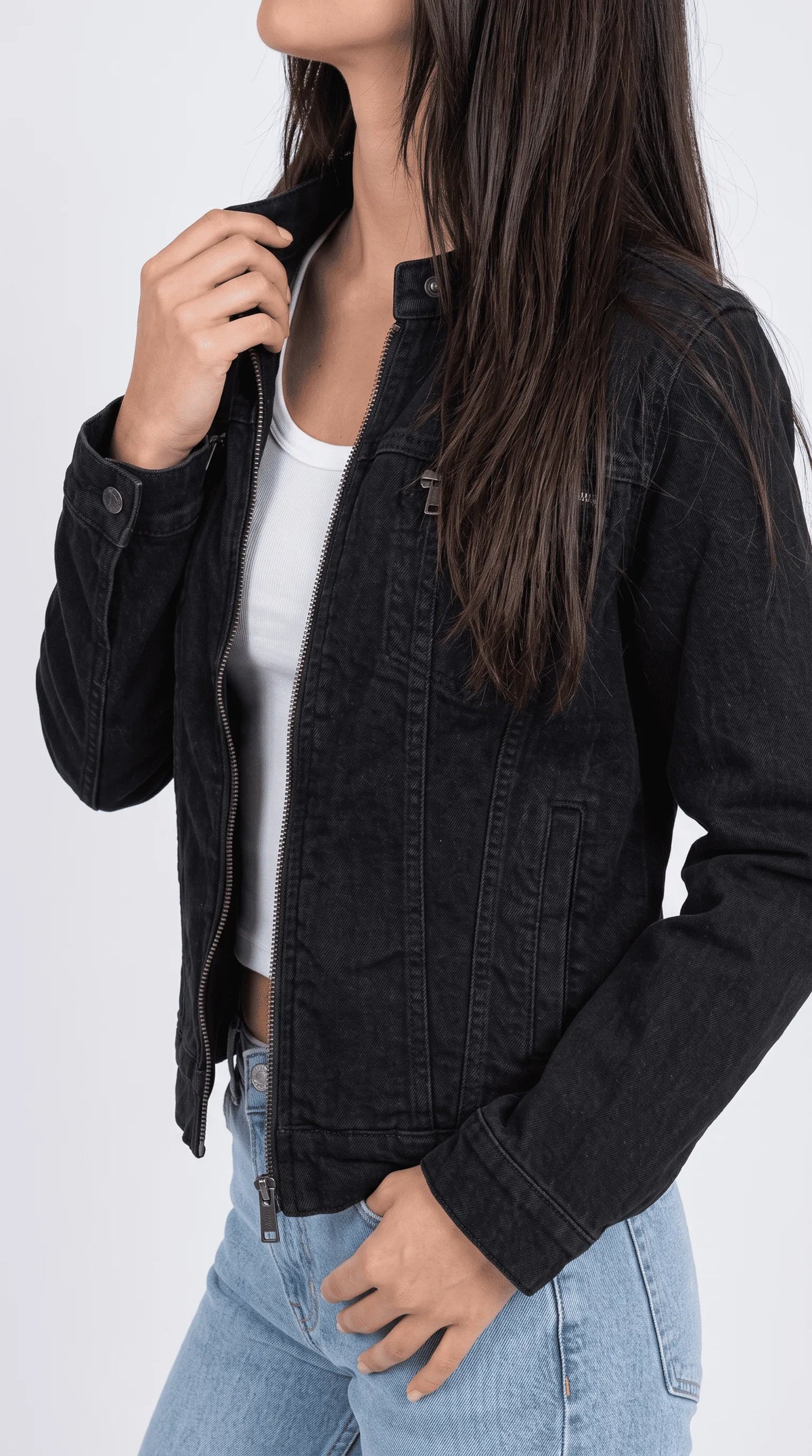 Black cotton denim cafe-racer jacket highlighting its snap-fastened mock collar, exposed silver front zipper, horizontal chest zip pocket and faded charcoal fabric texture for a sharp modern moto-inspired streetwear aesthetic.