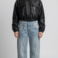 Front full view of premium black leather cropped jacket highlighting the modern short waist-length cut and clean zipper closure.