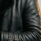 Close-up of a person wearing a black leather coat with fur collar.