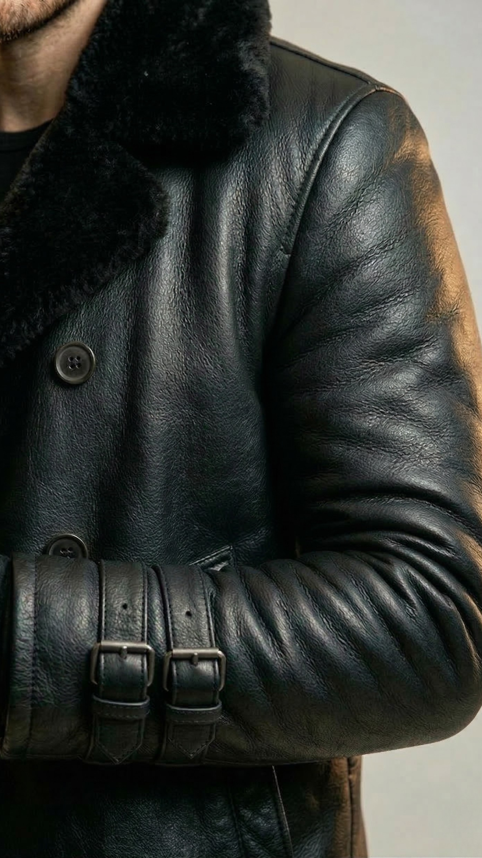 Close-up of a person wearing a black leather coat with fur collar.