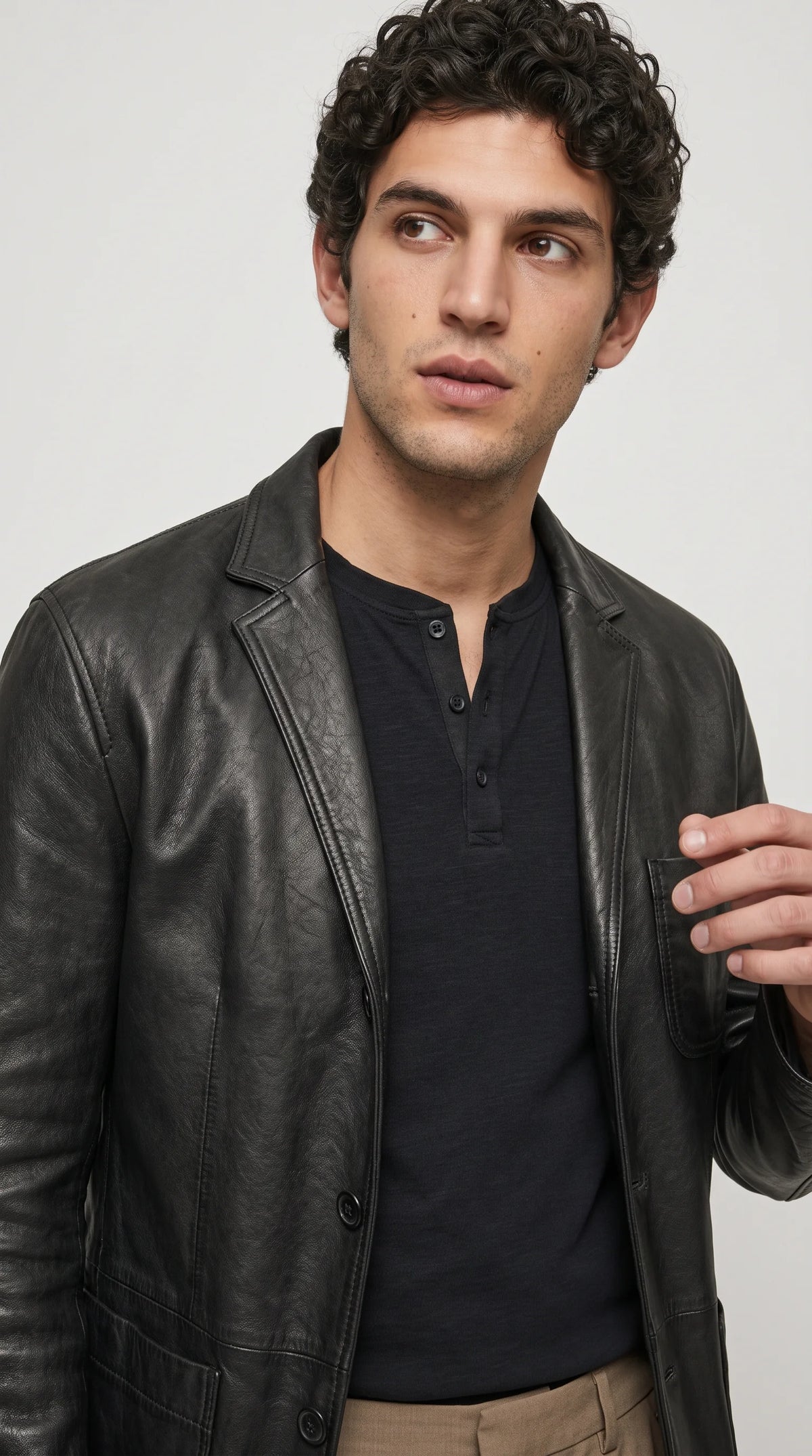 A black leather sportcoat showcases a naturally textured finish, sharply defined notch lapels, a stitched chest patch pocket and clean vertical panel seams. Its rich black surface and tailored construction bring a refined edge to contemporary menswear, making it a distinctive option for polished casual outfits, monochrome styling and modern leather fashion.