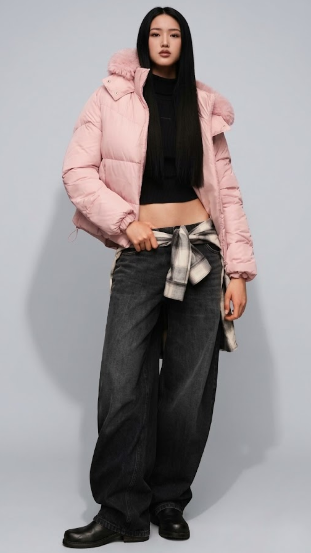 Model wearing a jackero high-end dusty rose pink quilted puffer jacket with a plush faux-fur trim hood, paired with black wide-leg denim jeans.