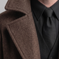Detailed look at the button hardware and classic collar styling of a brown wool coat.