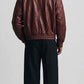 Back view showing dropped shoulders and baggy relaxed fit of dark red genuine leather flight jacket.