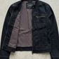 Flat lay professional photography of Jackero minimalist black denim jacket on a grey background