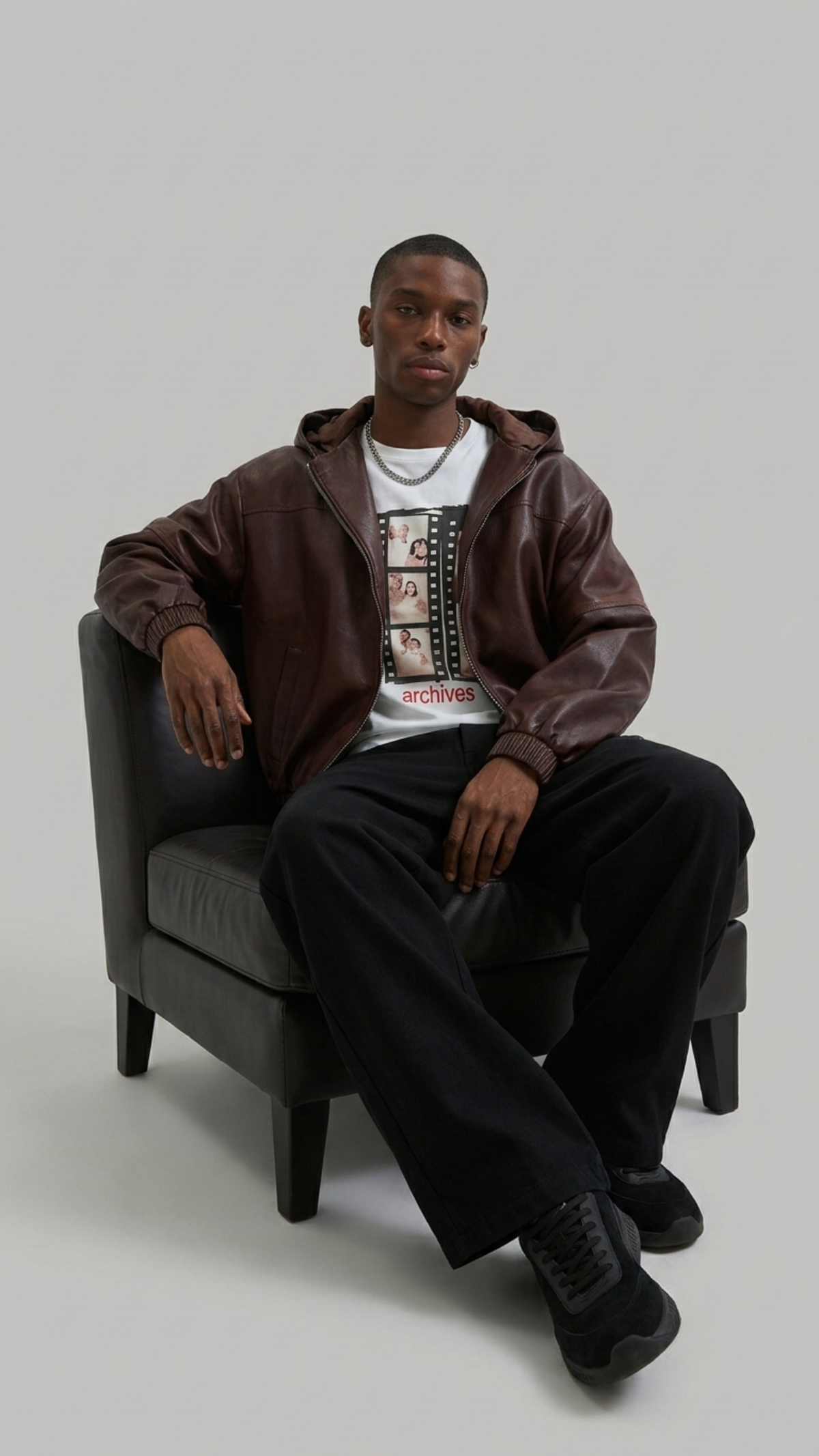 Men's slim fit genuine burgundy leather bomber jacket displaying clean stitching details, side pockets, and integrated casual grey hoodie fabric.