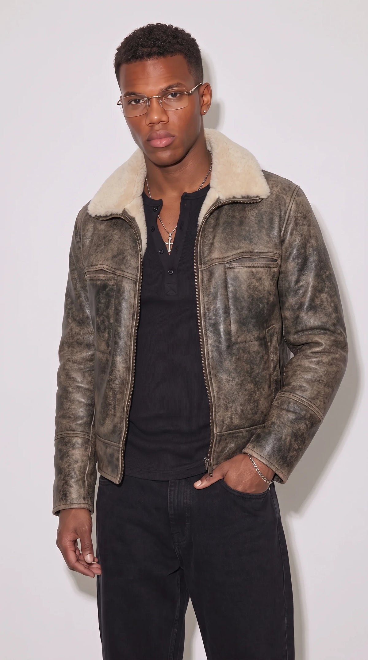 Charcoal-grey genuine leather aviator jacket with a multi-tonal distressed finish, plush white faux-shearling collar, full-length metal zipper and practical waist pockets, styled with a black henley shirt and dark denim for a rugged cold-weather streetwear outfit.