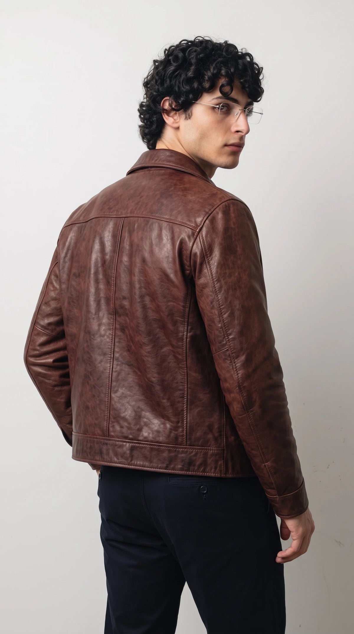 Back view of an oxblood red genuine leather jacket for men and women, showing the tailored silhouette and rich deep wine undertones of the semi-aniline leather