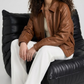 Studio fashion catalog shot of a women's tan leather coat with drop shoulders