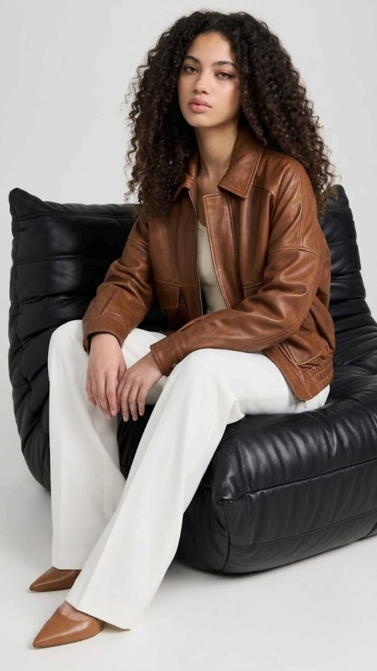 Studio fashion catalog shot of a women's tan leather coat with drop shoulders